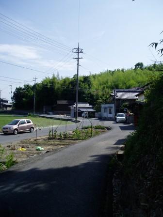 急なカーブを車が走っている様子を写した金田地区の路地の写真