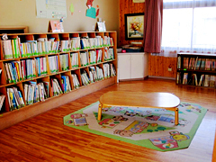 本がたくさん並べられた本棚や机が設置してある部屋の写真