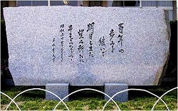長方形の石に数行にわたって文字が刻まれている100周年記念碑の写真