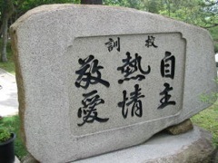 「校訓」「自主」「熱情」「教愛」と刻まれている石碑の写真
