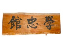 「館忠学」と刻まれた細長い木状の板の写真