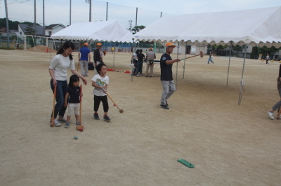 グラウンドでゲートボールを楽しむ保護者と子どもたちの写真