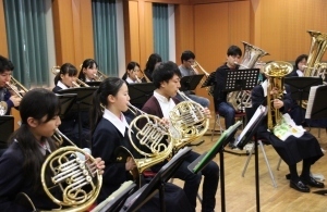 3人の男女の学生がホルンを吹いている写真