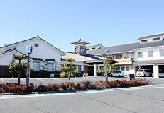 白を基調にした建物の地域福祉センター「オアシス早島」を駐車場側から撮影した写真