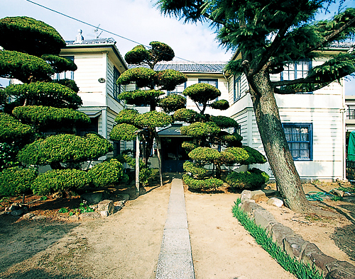 整えられた植木の奥に写る清澄家住宅の外観の写真