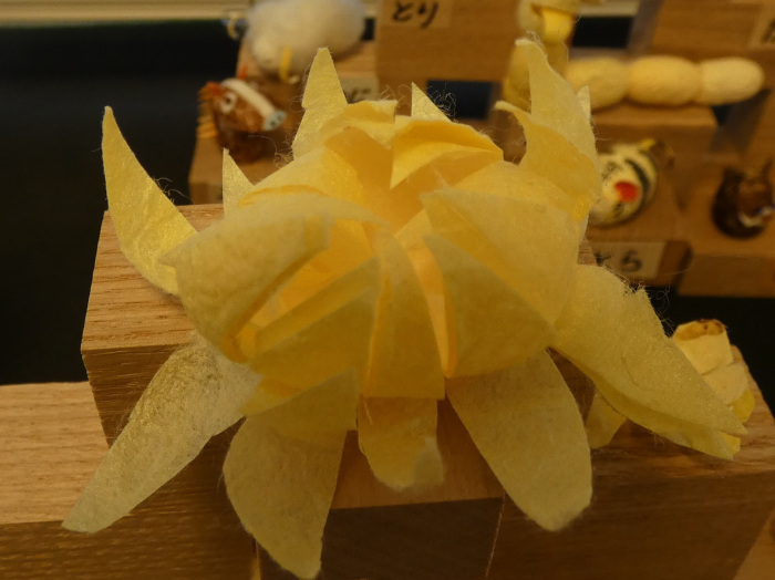 蚕のまゆで作られた花が開いている様子の作品の写真