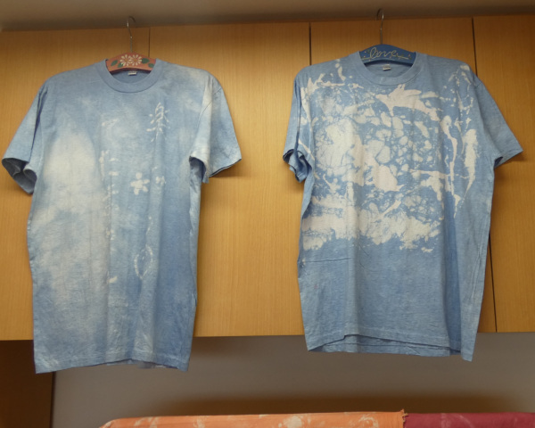 ろうけつ染めで作られた青い生地に白い模様が描かれている2枚のティーシャツの写真