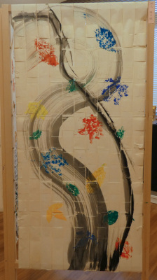 墨で描かれた川を葉っぱのスタンプが流されている様子が描かれた屏風の作品の写真