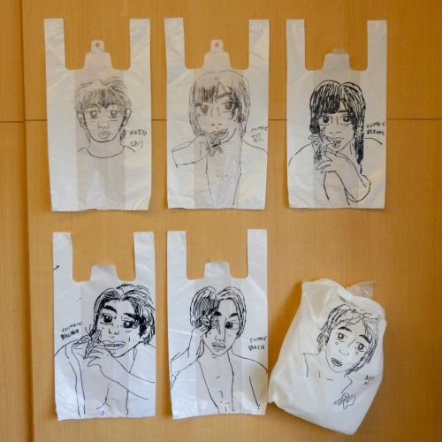 6枚の白いレジ袋にアイドルの顔が描かれていて右下のレジ袋のみやや斜めに傾いている写真