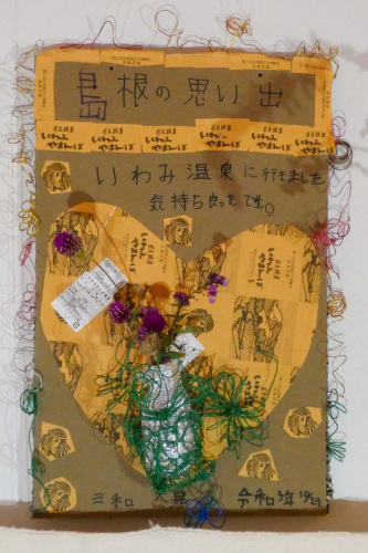 茶色い布に島根の思い出と書かれた下に花が糸でぐるぐる巻きにされている写真